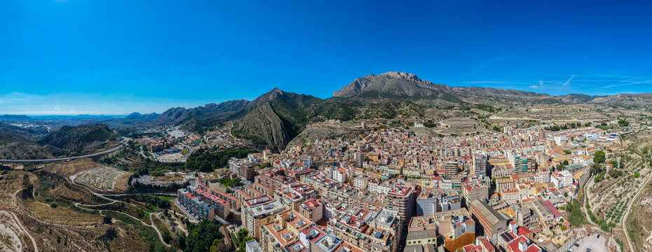 Aerial view of the historic town of Xixona, famous for its traditional turron production, nestled among rugged mountains and dry Mediterranean landscape in Xixona, Valencian Community, Spain.