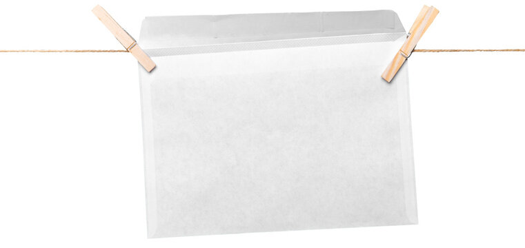 Envelope hanging on a string with clothespins in a simple setup against a plain background