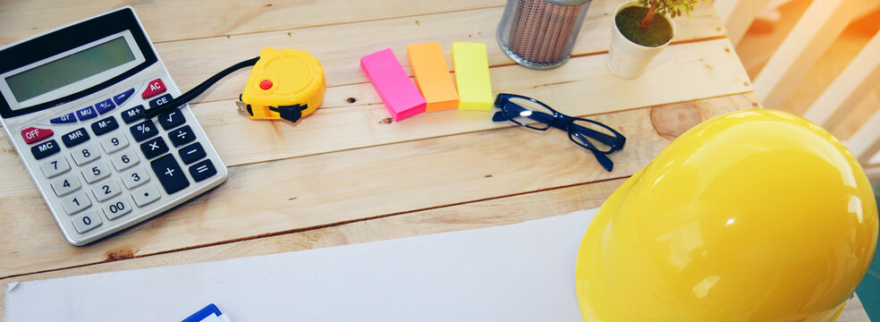 Banner Designer Objects drafting workplace on wooden table. engineer drawing objects table with meter, blueprint, hard hat engineering stuff on desk. Banner architecture project site manager on desk