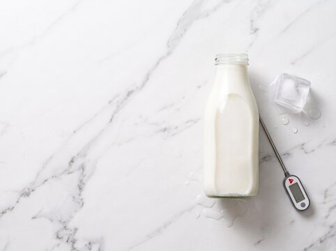 Glass Milk Bottle With Thermometer And Melting Ice Block