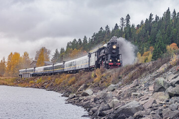 Retro steam train moves along the lake.  © serjiob74