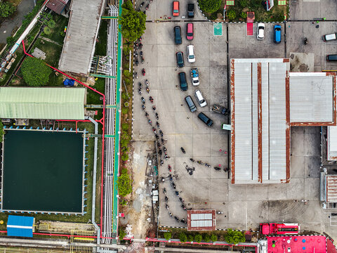 Aerial view of the PT. Pertamina TBBM Samarinda fuel terminal, showing a long queue of motorcycles and cars, industrial tanks, and infrastructure in Samarinda, East Kalimantan, Indonesia.