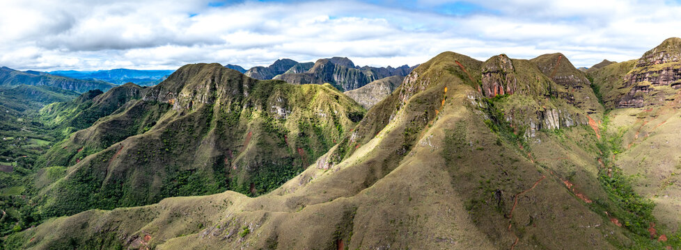 Aerial view of Codo de los Andes, showcasing the rugged mountain ridges, lush green slopes, and dramatic rock formations under a cloudy sky in Samaipata, Santa Cruz Department, Bolivia.