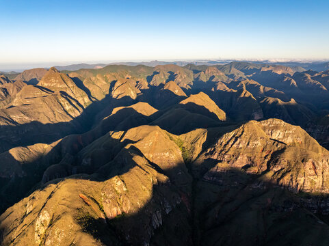 Aerial view of Codo de los Andes featuring rugged mountain peaks illuminated by golden hour light with deep shadows and dramatic terrain in Samaipata, Santa Cruz Department, Bolivia.