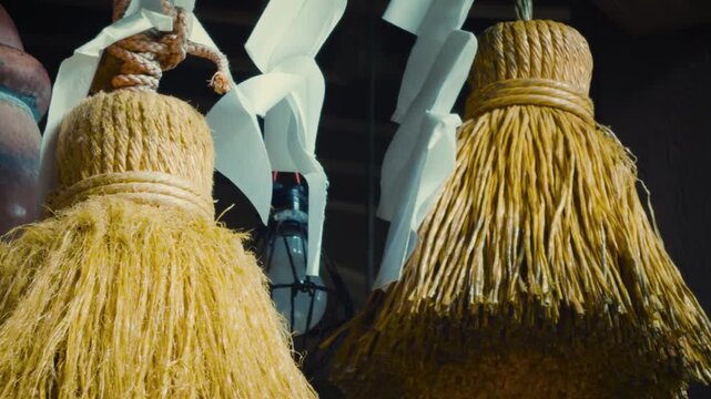 cinematic horizontal close-up shot panning right on a traditional japanese shinto shrine bell, colorful rope, shimenawa straw ropes and white shide paper streamers