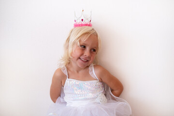  Little Blonde Girl Wearing Princess Crown and Dress on White Background © RealPeopleStudio