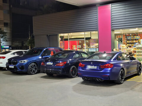 Blue BMW M4 Coupe Rear Three Quarter View Parked Outside Gas Station Store Night Scene Luxury Sports Cars