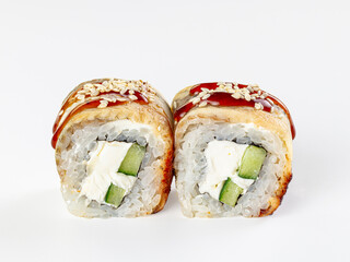 White surface showcasing two maki rolls with cream cheese, cucumber, eel, glazed sauce, and sesame seeds in Asian cuisine presentation © Andrei Starostin
