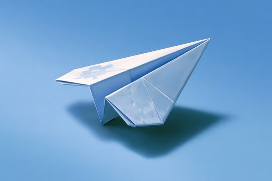Inclusive Artwork: Origami Paper Plane and Autism Puzzle Ribbon on Calm Blue Surface