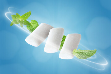 Menthol chewing gum pieces and mint leaves in air against blue background © New Africa