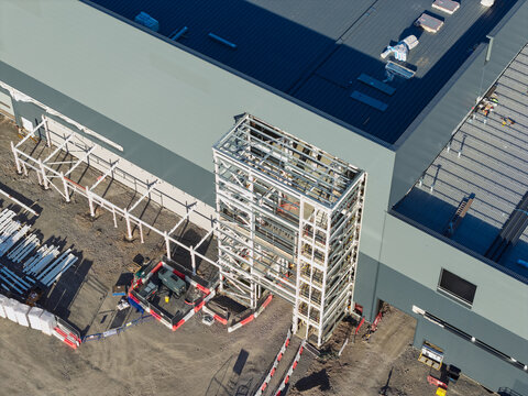 Aerial view of the Battery Gigafactory construction site featuring a steel frame structure, industrial roofing, and ground-level equipment in the United Kingdom.