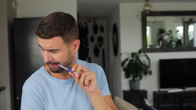 Distracted Man Thoughtfully Biting Pen While Thinking