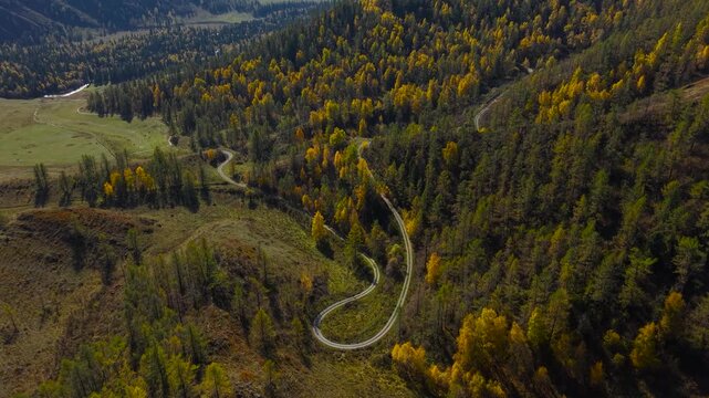 Drone slow flight forward revealing the old scenic winding mountain road of Chike-Taman pass in autumn.