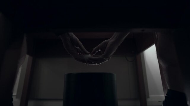 Unusual view of a person shelling a boiled egg in a dark hotel room