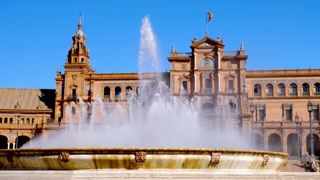 fountain splashing in front of landmark plaza de espana building under clear blue sky in seville spain
