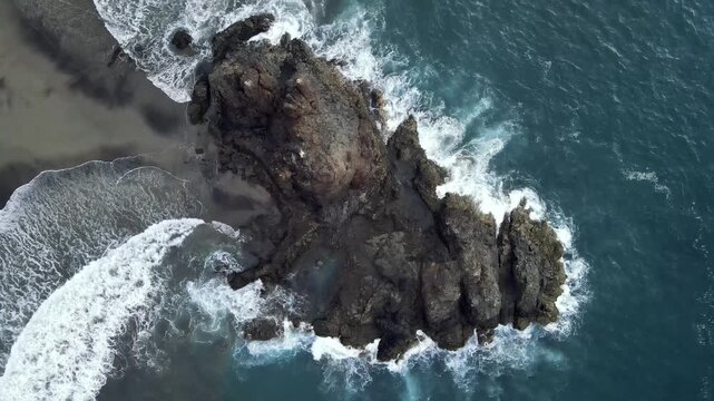An extended overhead drone view watches surf circle the jagged Benijo rock cluster again and again. The longest top down sequence of the set on Tenerife's black sand coast.