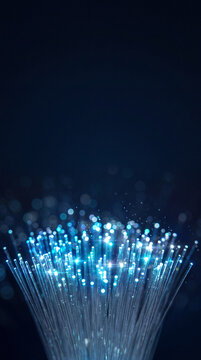 Fiber optic cables transmitting data with blue light on dark background. Cybersecurity and digital network infrastructure. Secure data transmission and telecommunications technology.