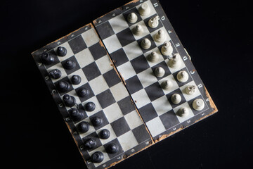 Top view, A chessboard against a black background. a game that relies on strategy and intellect. © Randa