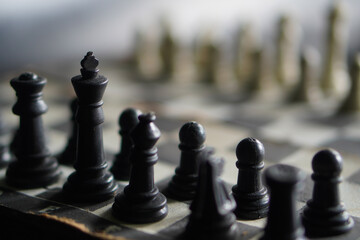 Close up, A chessboard against a black background. a game that relies on strategy and intellect. © Randa