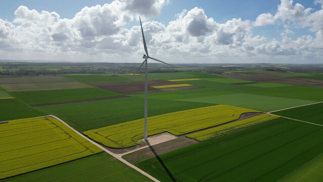 &Eacute;olienne au milieu de champs de colza en fleurs sous de gros nuages