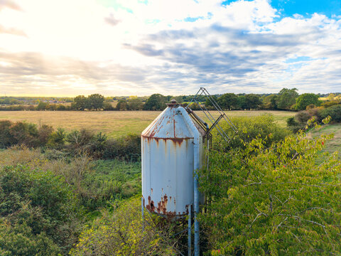 Interesting view of a once-used farm grain silo, now is disrepair as seen in the Essex, UK countryside. The once dairy farm had heard of milking cows on the surrounding meadows.
