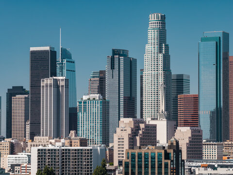 Downtown Los Angeles skyline features modern highrise towers including US Bank Tower, Aon Center, and Wilshire Grand Center on a bright sunny day in California.