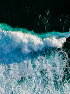 Aerial view of powerful ocean waves crashing with white foam and turquoise water in Sandpatch, Western Australia, Australia.