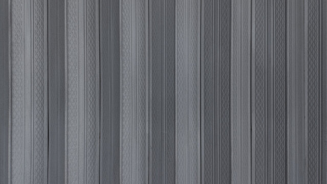 Monochromatic vertical striped pattern texture with textured geometric ridges and grooves. Grey architectural wall cladding background for minimalist interior design and backdrop.