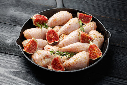 Raw Chicken Drumsticks with Fresh Figs and Rosemary in Cast Iron Skillet
