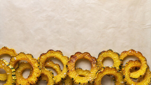 Roasted delicata squash rings macro on white parchment paper copy space