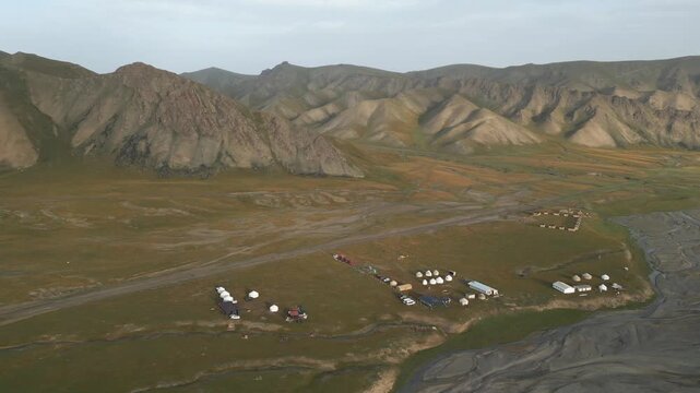 Stunning aerial footage showing a traditional yurt encampment settled in the vast, remote landscape of Kok Kiya Valley in Kyrgyzstan