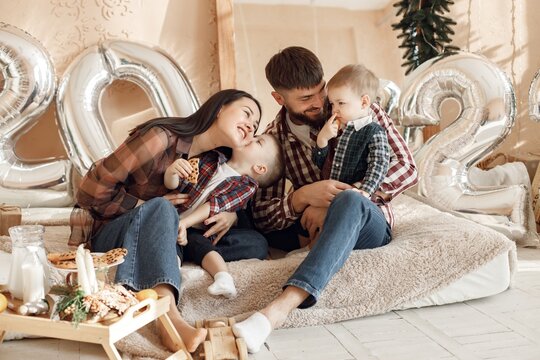 Young family in plaid shirts sitting on a floor near mirror
