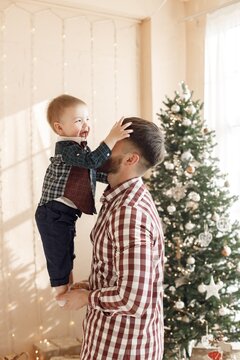 Father with son standing in room near Christmas tree