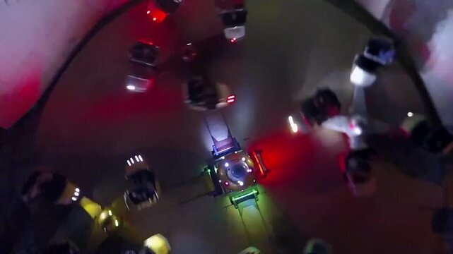 Drone rising above a spinning disco ride lit in red and blue at a funfair, Mosul, Iraq