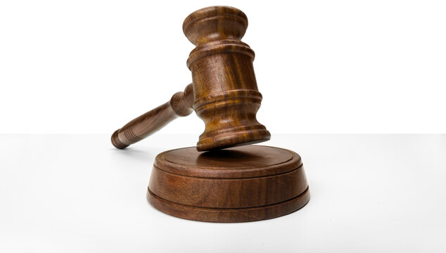 Wooden gavel placed on a round block on a white surface in a legal setting