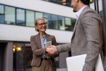 Establishing business partnership with handshake outside office © Jelena