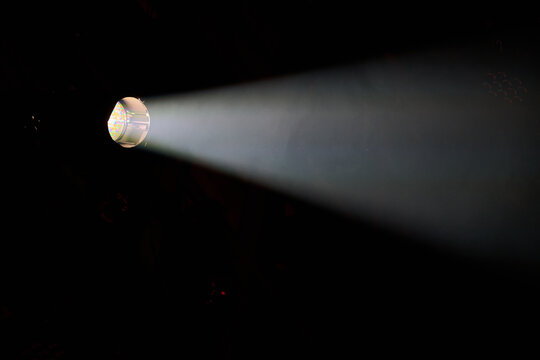 Stage spotlight casting a bright beam of light in a dark venue in Rybnik, Poland