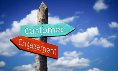Customer engagement - wooden signpost with two arrows, sky with clouds © PX Media