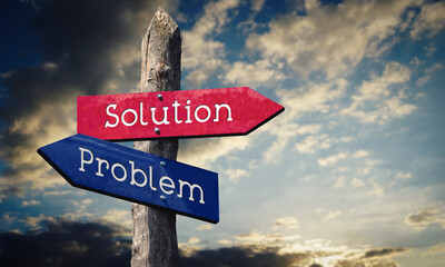 Problem and solution - wooden signpost with two arrows, sunset sky in background © PX Media