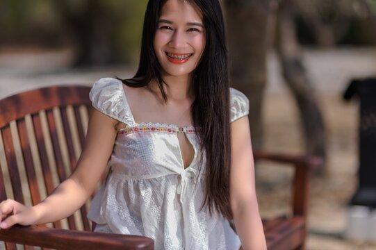 Smiling Woman Relaxing on Bench During Vacation in Koh Si Chang, Thailand