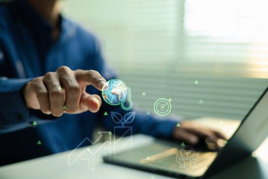 Business professional using a laptop and touching a digital globe and thermometer icon, with green growth charts and eco symbols illustrating climate monitoring and sustainable strategy.