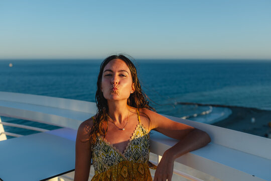 Woman pouting playfully on a rooftop terrace overlooking the sea