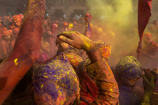 Hand on head of turbaned man in colored powder at Braj Ki Holi, Nandgaon, India