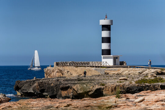 sailboat passing in front of a coastal lighthouse, Colonia de Sant Jordi, Ses Salines, Mallorca, Balearic Islands, Spain