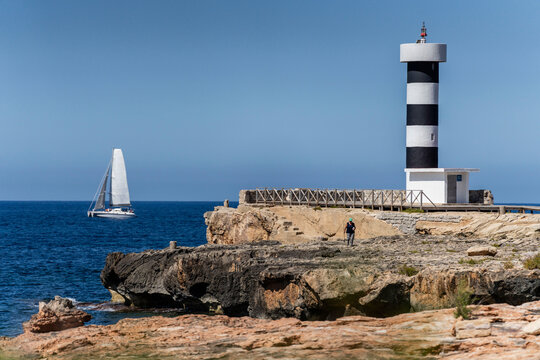 sailboat passing in front of a coastal lighthouse, Colonia de Sant Jordi, Ses Salines, Mallorca, Balearic Islands, Spain