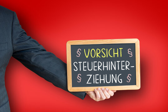 Person im Anzug h&auml;lt Tafel als Warnung vor Steuerhinterziehung und Wirtschaftskriminalit&auml;t