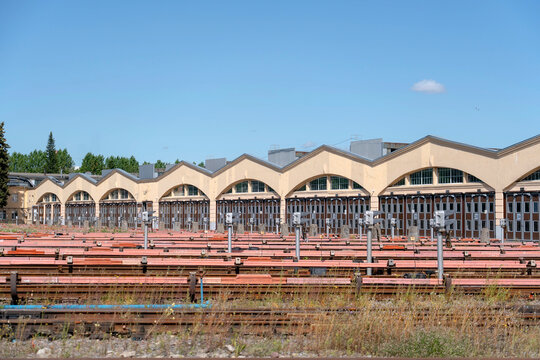 Dismantled passenger train bodies and scattered metal debris fill an outdoor railway scrapyard, highlighting recycling materials and end-of-life rail equipment.