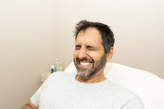 Man experiencing discomfort during hair removal treatment