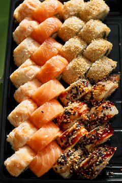 Assorted sushi rolls with salmon and shrimp served on a black plate