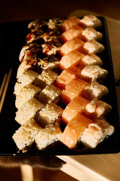 Assorted sushi rolls with salmon and shrimp served on a black plate